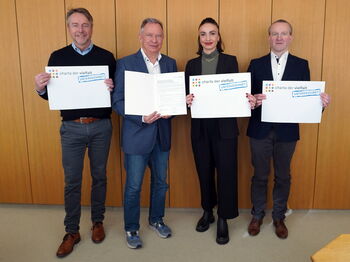 Landrat Stephan Pusch (2.v.l.) und die KI-Mitarbeitenden Leo Stepprath (von links),  Dr. Asli Topal-Cevahir und Bernd Laprell zeigen die unterzeichnete Charta der Vielfalt. Foto: Kreis Heinsberg