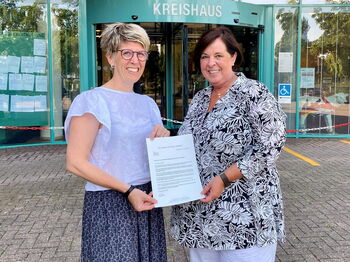 Dezernentin Anja Montforts (l.) händigte der neuen ehrenamtlichen Behindertenbeauftragten, Andrea Pesch (r.), vor dem Kreishaus die Bestellungsurkunde aus. Foto: Kreis Heinsberg