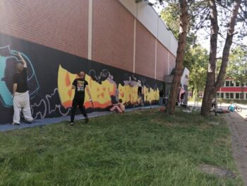 Jugendliche sprühen ein Graffiti-Kunstwerk an die Wand der Sporthalle in Wegberg