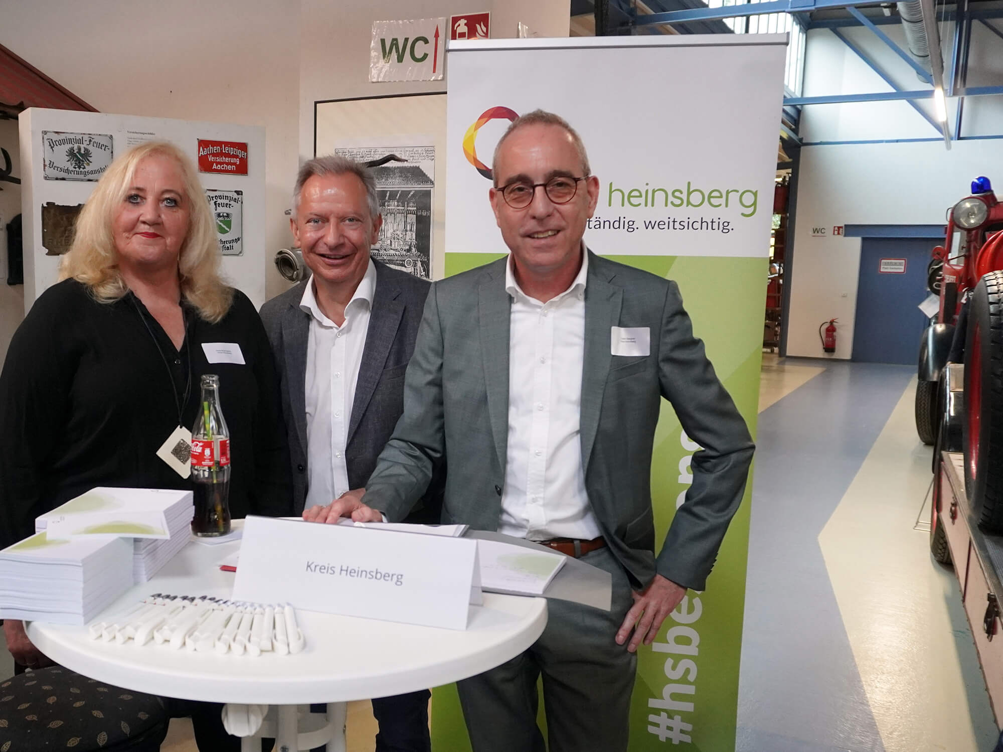 Gleichstellungsbeauftragte Petra Büschgens (v.l.), Landrat Stephan Pusch und Hauptamtsleiter Frank Steigner begrüßen die Teilnehmerinnen im Lövenicher Feuerwehrmuseum. Foto: Kreis Heinsberg